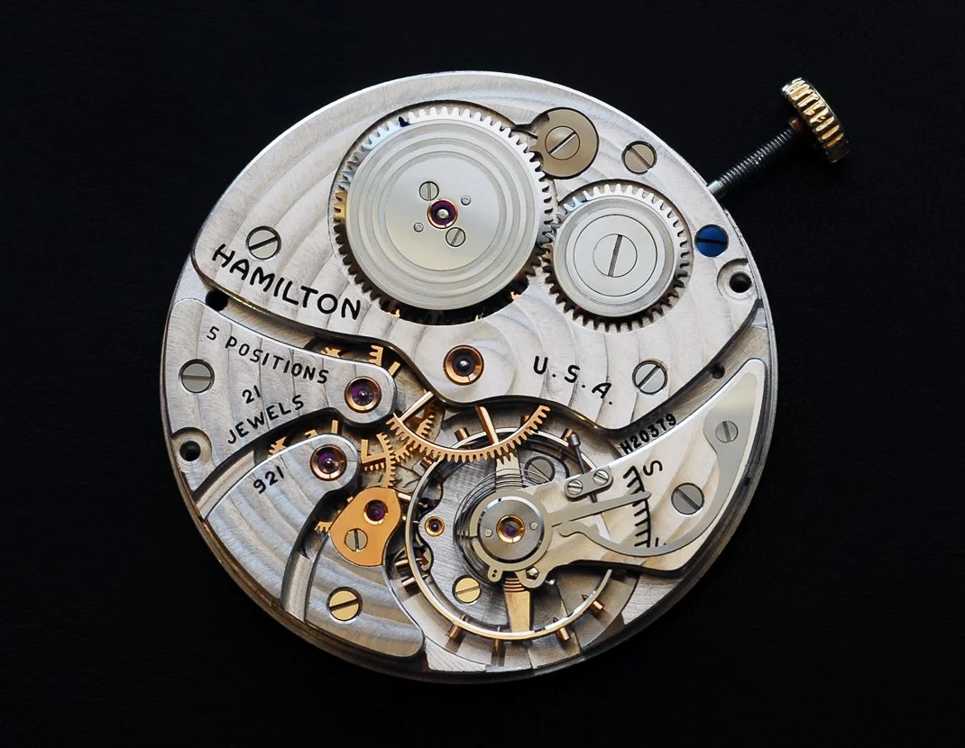 Intricate Hamilton watch movement showing gears, jewels, and precision craftsmanship